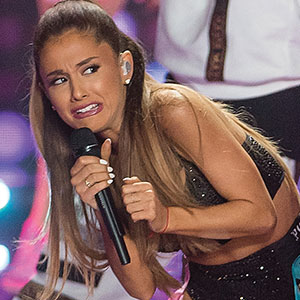 Ariana Grande performs with a grimace