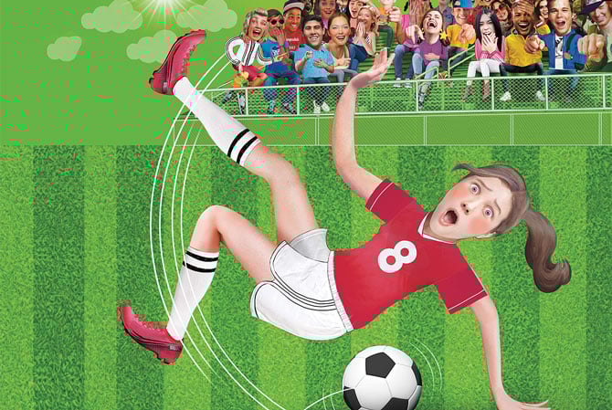 a girl in a soccer uniform falling in front of a crowd