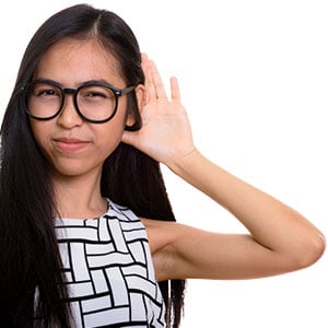a woman holding her hand up by her ear to hear better