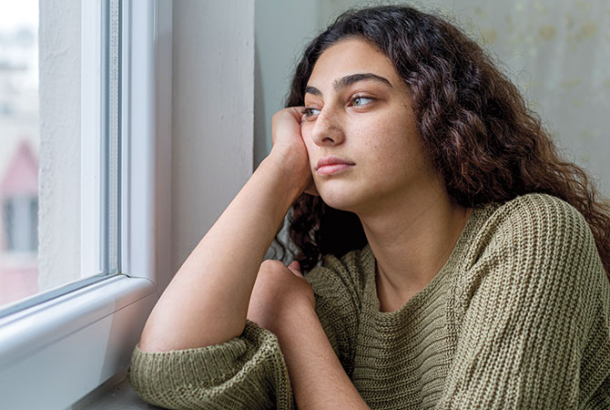 A sad teen staring out the window