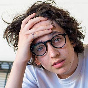 Photo of a teen with hand on forehead in slight exasperation
