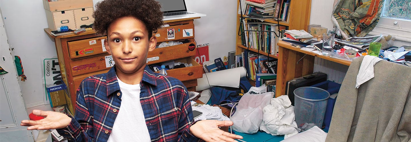 Image of kid shrugging while standing in front of a messy room