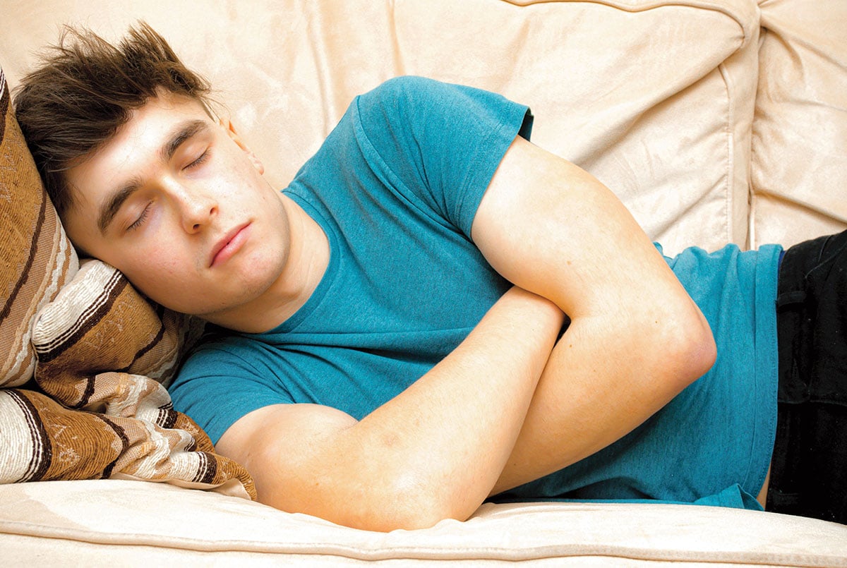 a boy sleeping on a couch