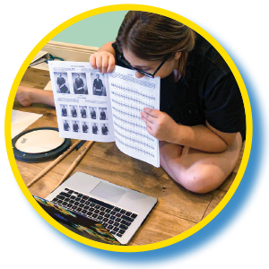 Person videochatting while showing a page from their music book